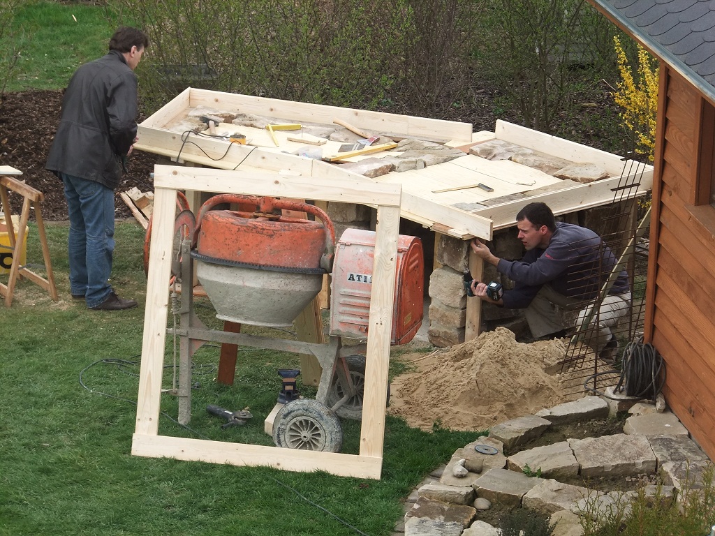 an dem Betonmischer lehnt eine Schablone für die spätere Fläche für den Ofen