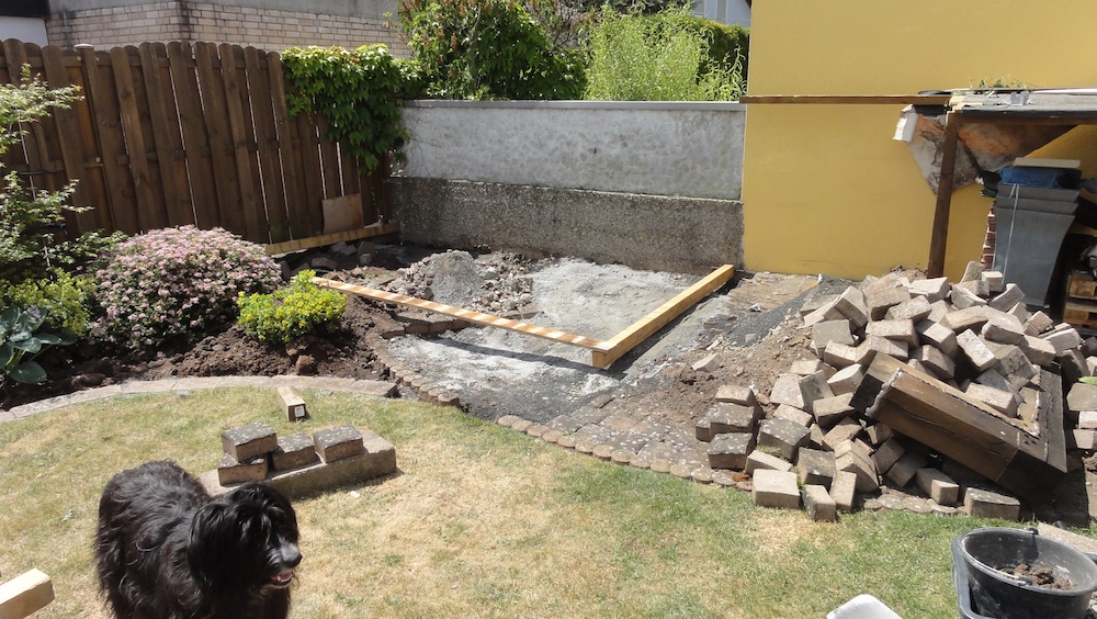 Die Fläche unter dem Holzschuppen mit den panisch rausgeholten Pflastersteinen.