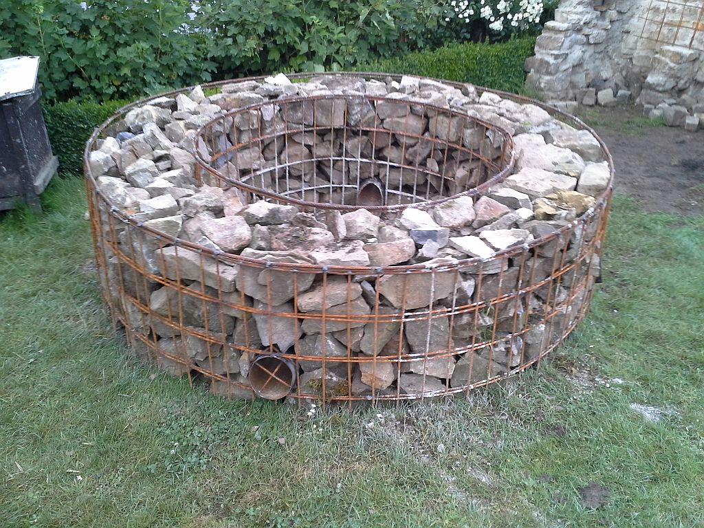 Die Steine sind jetzt im Korb . Ich hab sie mit dem Vorschlaghammer verdichtet somit hat der Korb auch Form bekommen .