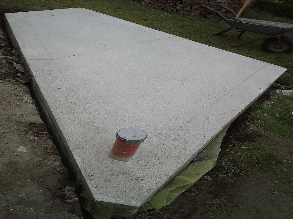 Nach zwei Tagen ausgeschalt und mal den Grundriss des Ofenunterbaus aufgerissen . <br />Ich bürste übrigens Betonflächen ab , sobald ich ohne Spuren darauf laufen kann. Somit beseitige oder verhindere ich die Bildung einer Sinterschicht , die später wie eine Trennschicht wirken würde .